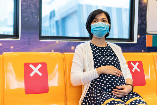 Asian Pregnant Woman in face mask traveling to work by commuter