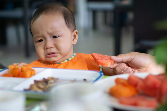 Cute 5-6 month asian baby girl doesn't want to eat watermelon