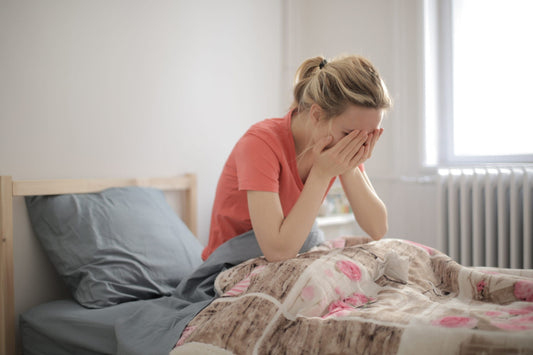 Shallow focus shot of a crying female who is lying in bed